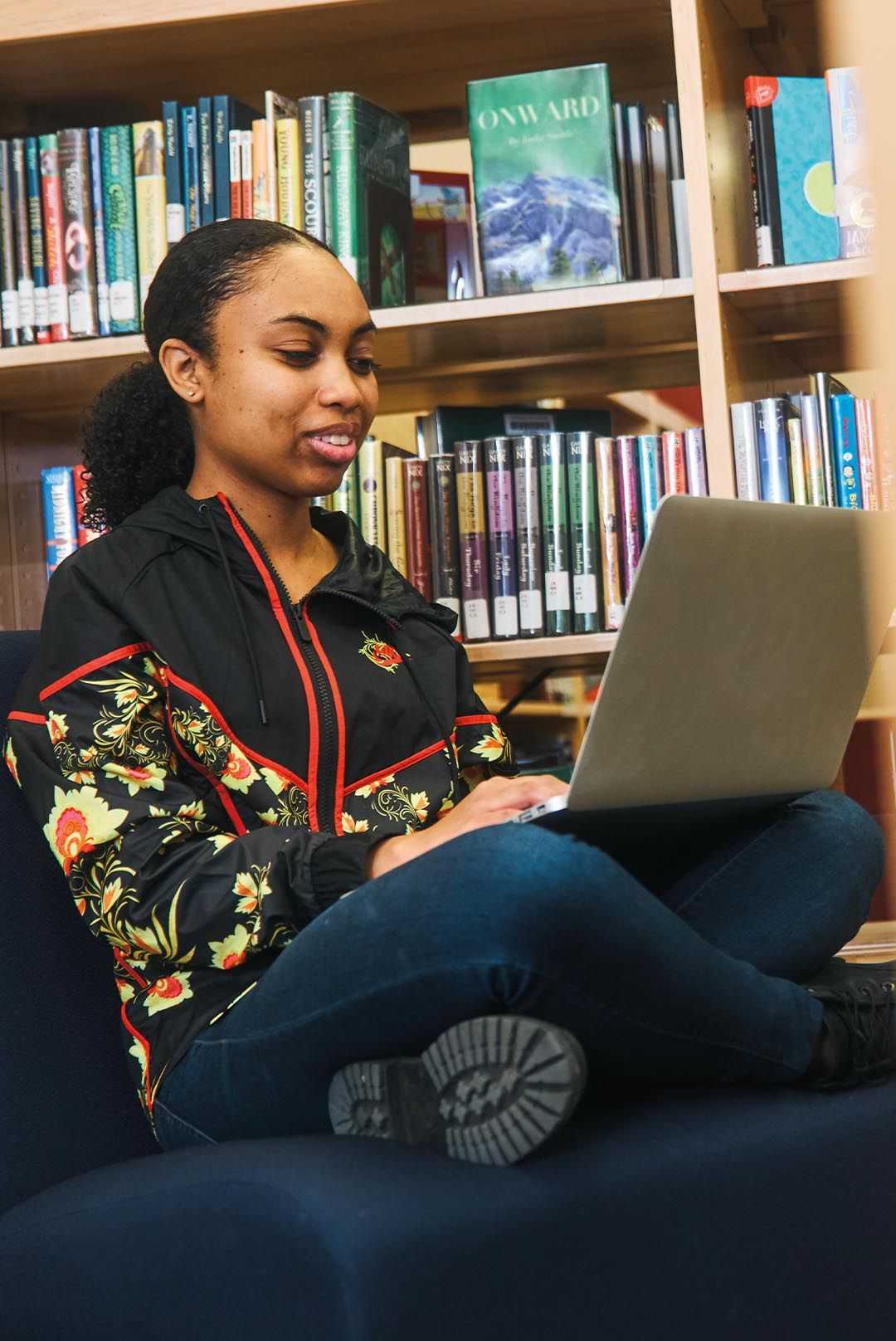 Woman sitting cross legged with a laptop in front of her