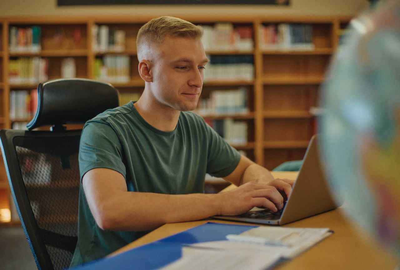 A student works on his laptop in a library