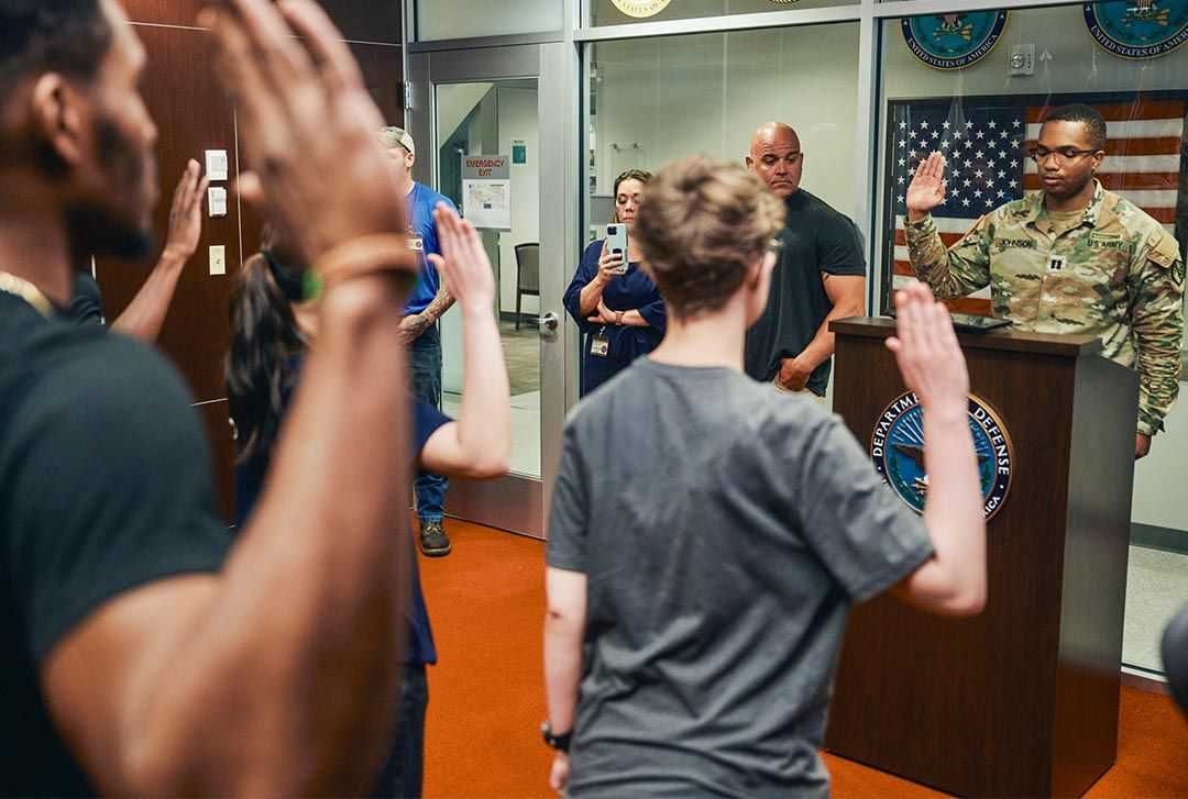 A soldier swears in new recruits in front of their friends and families