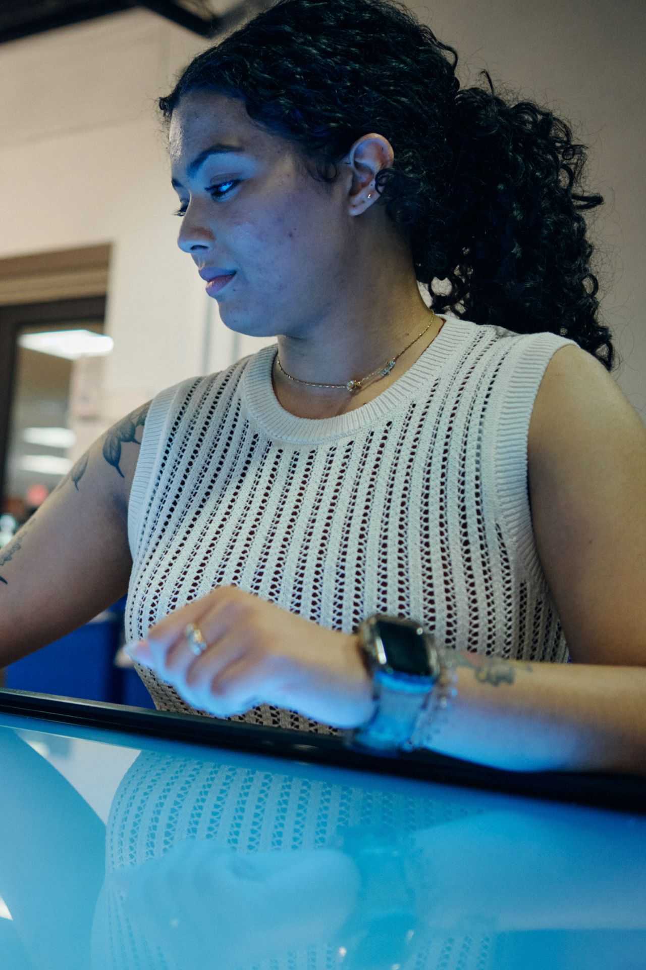 A woman interacts with a touch screen computer, focused on the display