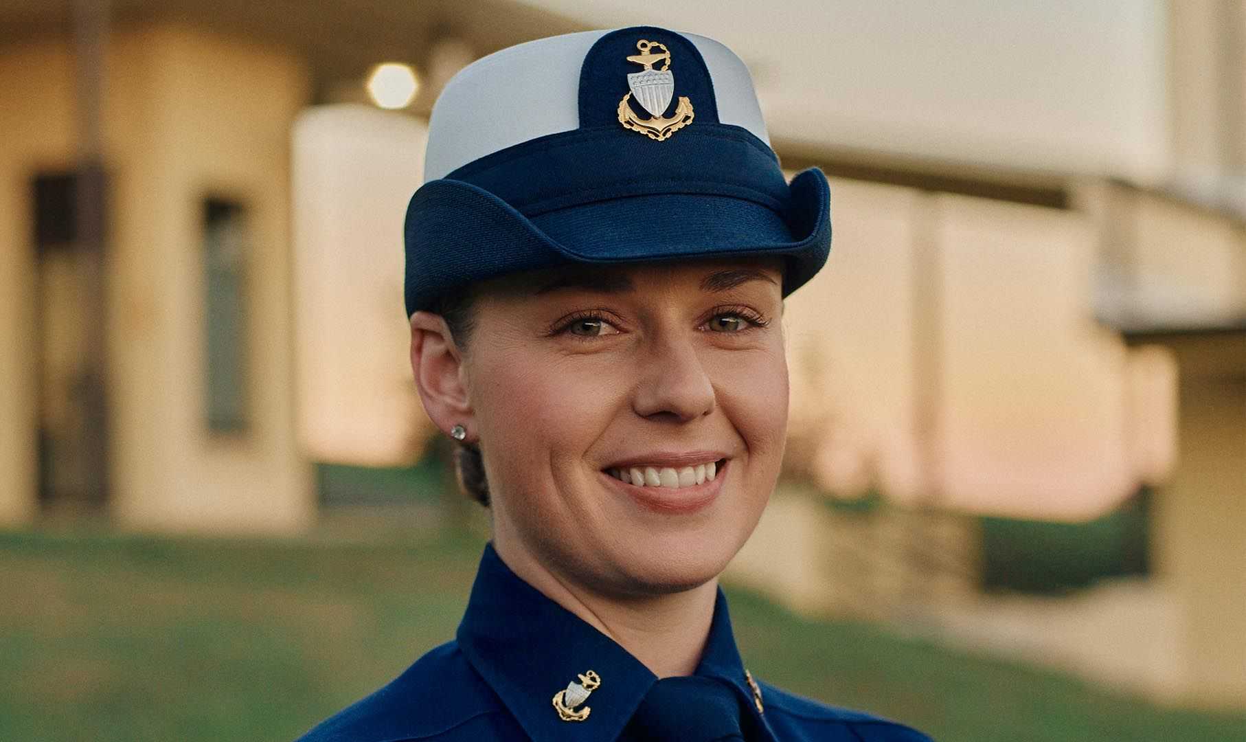A smiling woman in uniform poses for the camera